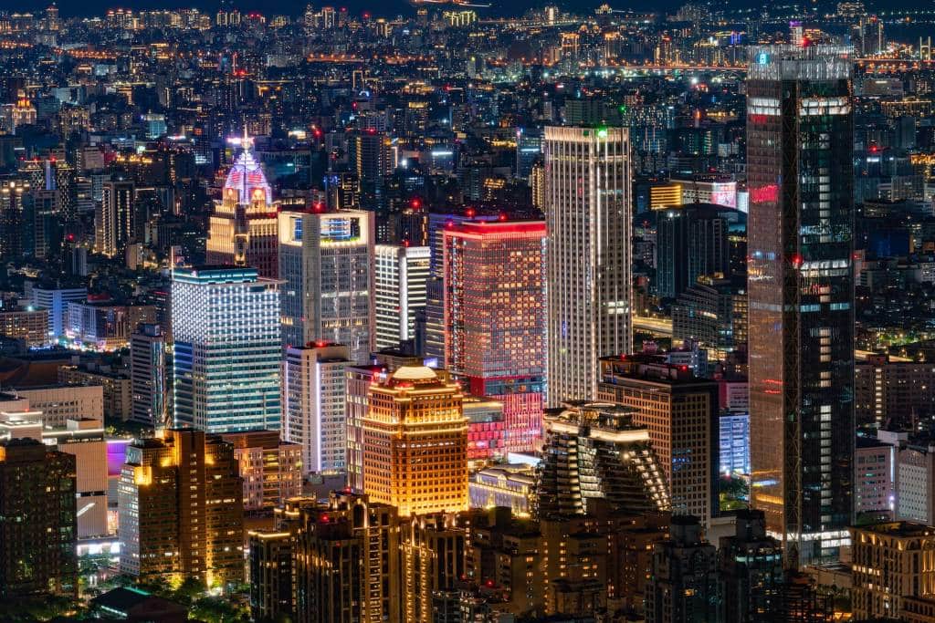 a view of a city at night from the top of a skyscraper